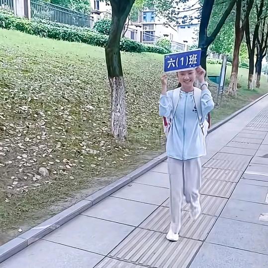 举班牌的小姑娘